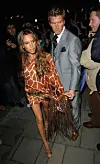 Victoria Beckham iført Roberto Cavalli og David Beckham i grå dress.