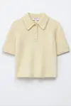 Kortermet smørgul topp med krage og knapper mot hvit bakgrunn.