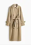 Beige lang trenchcoat med belte og dobbelknepping mot hvit bakgrunn.