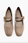 Et par kamelfargede ballerinasko med rem og gullspenne sett ovenfra mot hvit bakgrunn.