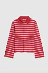 Rød og hvit stripete polotrøye med lange ermer mot lys bakgrunn.