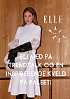 Kvinne i hvit kjole poserer foran trevegg med ELLE og Paleet-logo og invitasjonstekst.