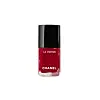 En liten flaske rød Chanel Le Vernis neglelakk med svart kork på hvit bakgrunn.
