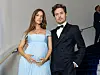 Barbara Palvin og Dylan Sprouse står ved en trapp, mens Palvin holder hendene på gravidmagen.