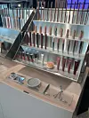 Lys butikkdisken med flere rader av CAIA-sminke, hudpleieprodukter og beauty tools i en moderne utstilling.