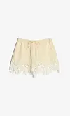 Lysegule shorts med blondekant og snøring, vist mot en hvit bakgrunn.