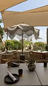 Utendørs restaurantområde med parasoll, bord og stoler under solseil på Dunes Beach i Marbella