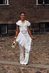 Nina Sandbech poserer i et hvitt, dekorativt antrekk med blonder, frynser og vide bukser under Copenhagen Fashion Week.