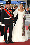 Kronprins Haakon i uniform og Mette-Marit i hvit brudekjole på rød løper.