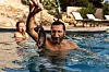 Fares Fares holder en fisk over vannet i et basseng, med Frida Gustavsson synlig i bakgrunnen.