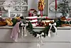 Julepyntet skjenk med servise, kaker, grønne girlandere og store sløyfer i rødt og hvitt.