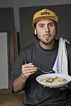 Oliver Ingrosso holder en tallerken med pasta og en gaffel foran kamera.