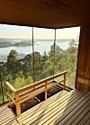 Panoramasauna i tre med benker og utsikt over fjord, skog og øyer.