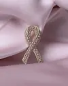 Rosa sløyfe i rosegull med perler på et lyst rosa stoff.