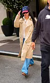 Rihanna går i New York iført lys trenchcoat, caps, solbriller, jeans og sneakers.